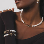 Femme noire qui allie raffinement et modernité avec ses deux bracelets coordonnés en perles et maillons dorés, parfaits portés ensemble ou separement pour varier les styles. Ces perles se marient a la perfection avec les details dorés. C'est un bijou pensé pour magnifer la silhouette et apporter une touche de lumière intemporelle