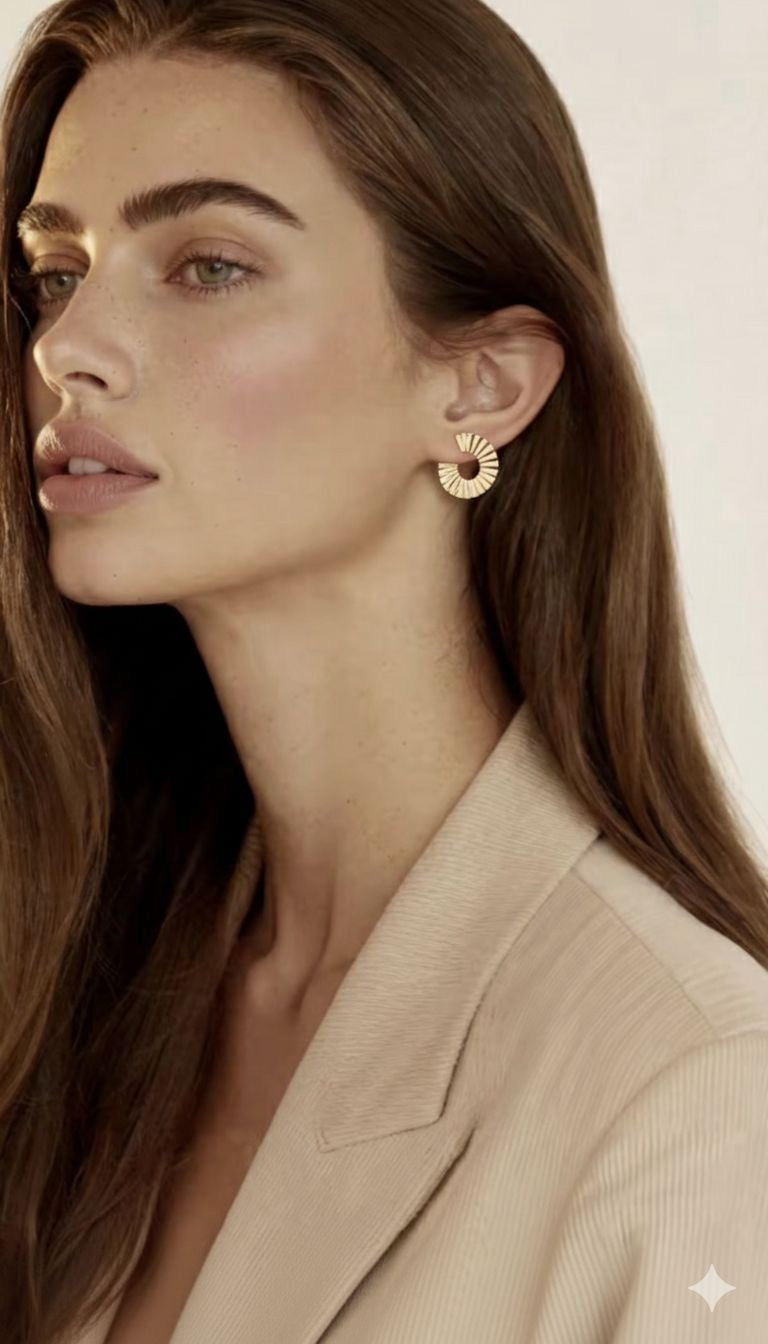 Jolie jeune femme chatain, peau blanche légèrement maquillée, fard à joue, maquillage nude, longs cheveux, yeux clairs, une oreille dégagée, qui laisse voir la boucle d'oreille parfaite, doré or, solaire , d'une taille idéale. Un rond de 2 cm comme un soleil rayonnant, un parfait cadeau à offrir, réussite garantié