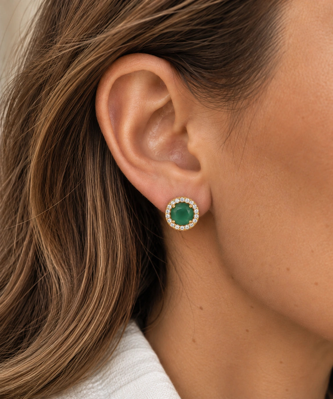 Boucle d’oreille puce Alba en onyx vert naturel, halo de zircons et plaqué or 18 carats, portée sur l’oreille. »