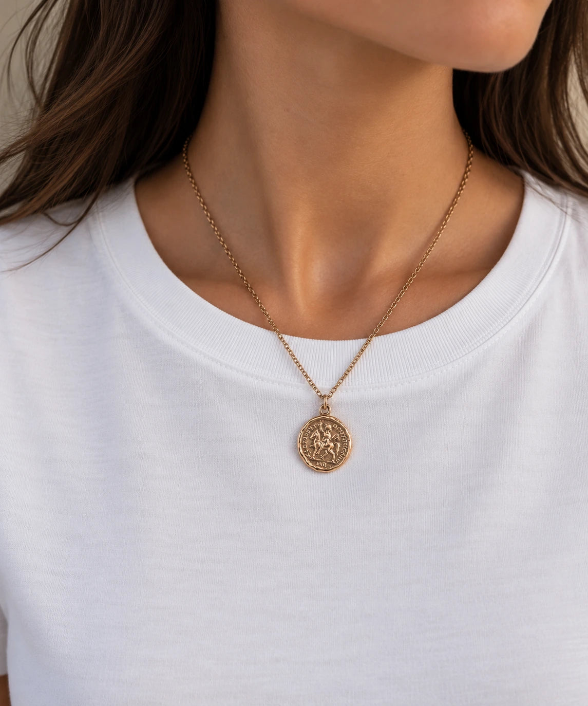 buste de jeune femme qui porte un collier doré médaille ronde inspiration piece de monnaie ancienne vintage qui représente un cavalier sur son cheval 