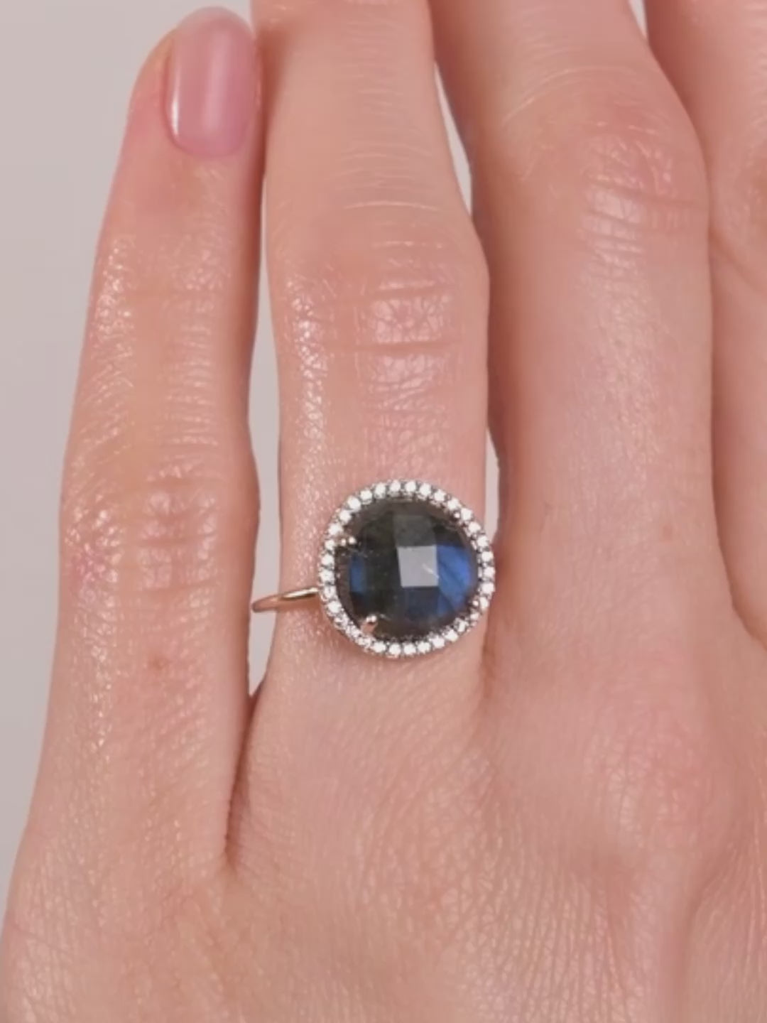 video zoom de la bague alba labradorite avec ses reflets feu bleus sublimes sur une main peau blanche 